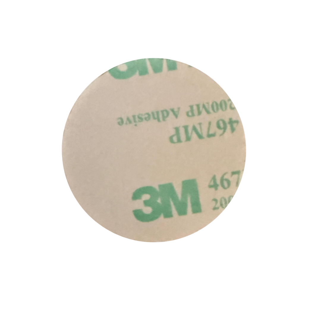 Round piece of paper with '3M' adhesive label on a white background