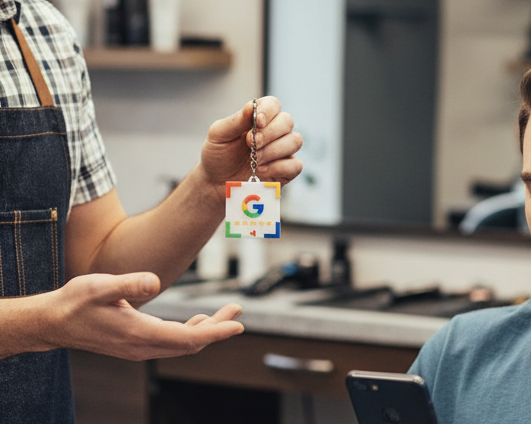 Barber showing a smartphone to a customer in a barbershop.