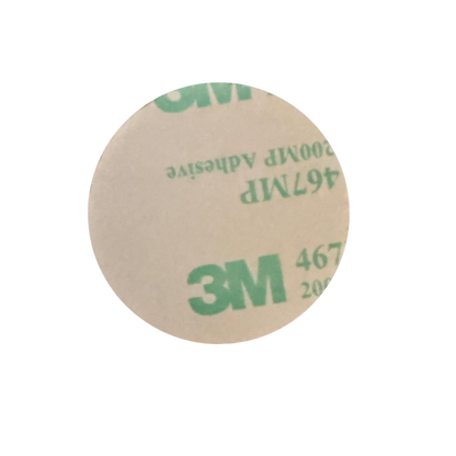 Round piece of paper with '3M' adhesive label on a white background
